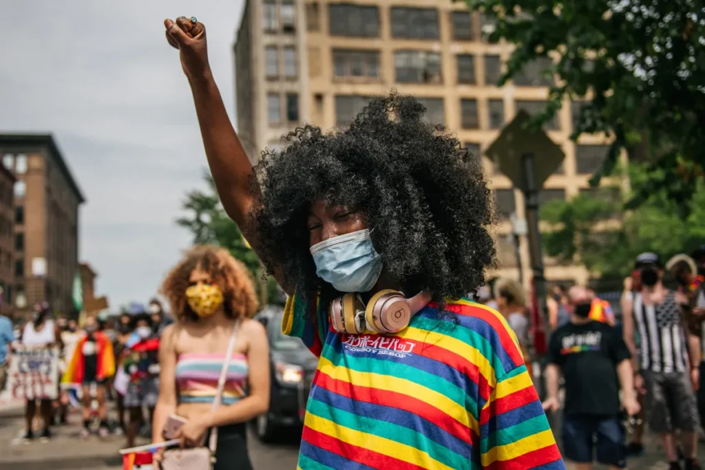 black woman rainbow shirt mask raised fist cred Brandon BellGetty Images web